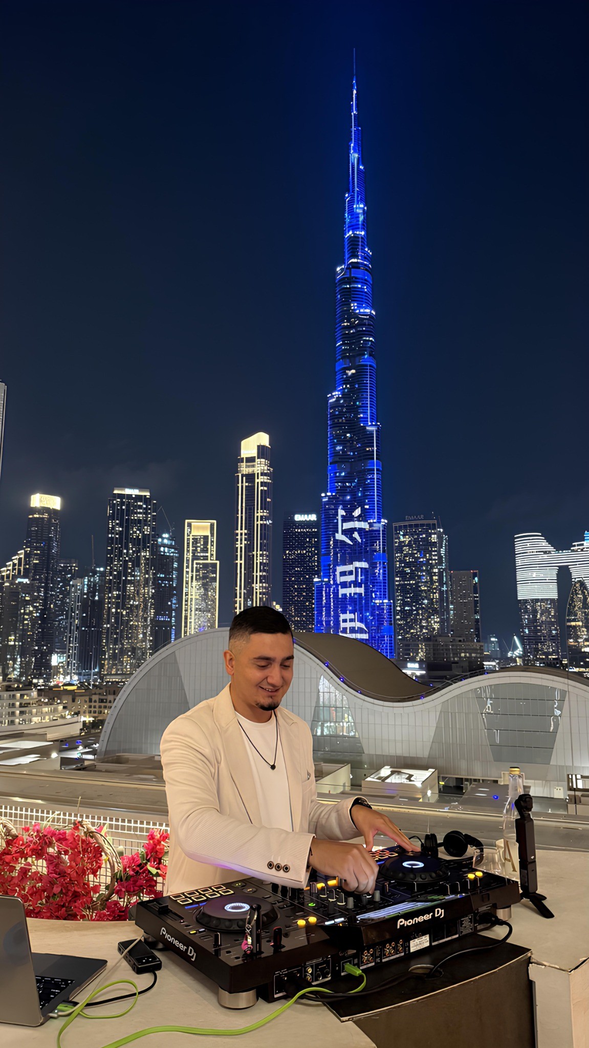 DJ KAYA performing with the Downtown Dubai skyline and Burj Khalifa